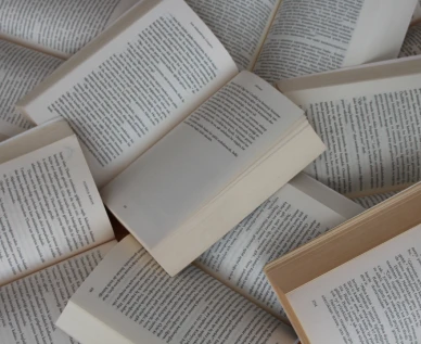 Varios libros abiertos apilados en desorden
