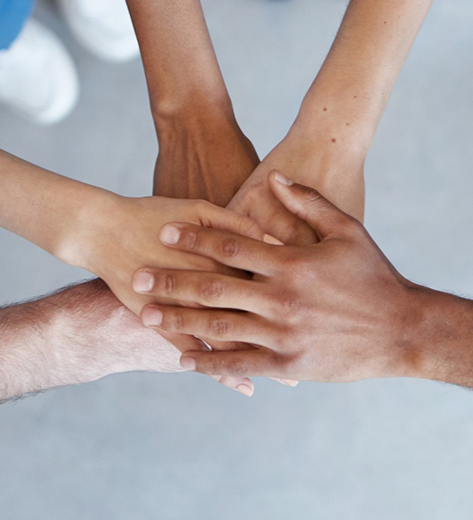 Askotariko etniaetako pertsonen eskuak elkarren artean
