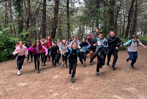 Niños del campus Neptuno corriendo en un bosque