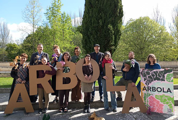 Un grupo de gente posando y anunciando el festival arbola.
